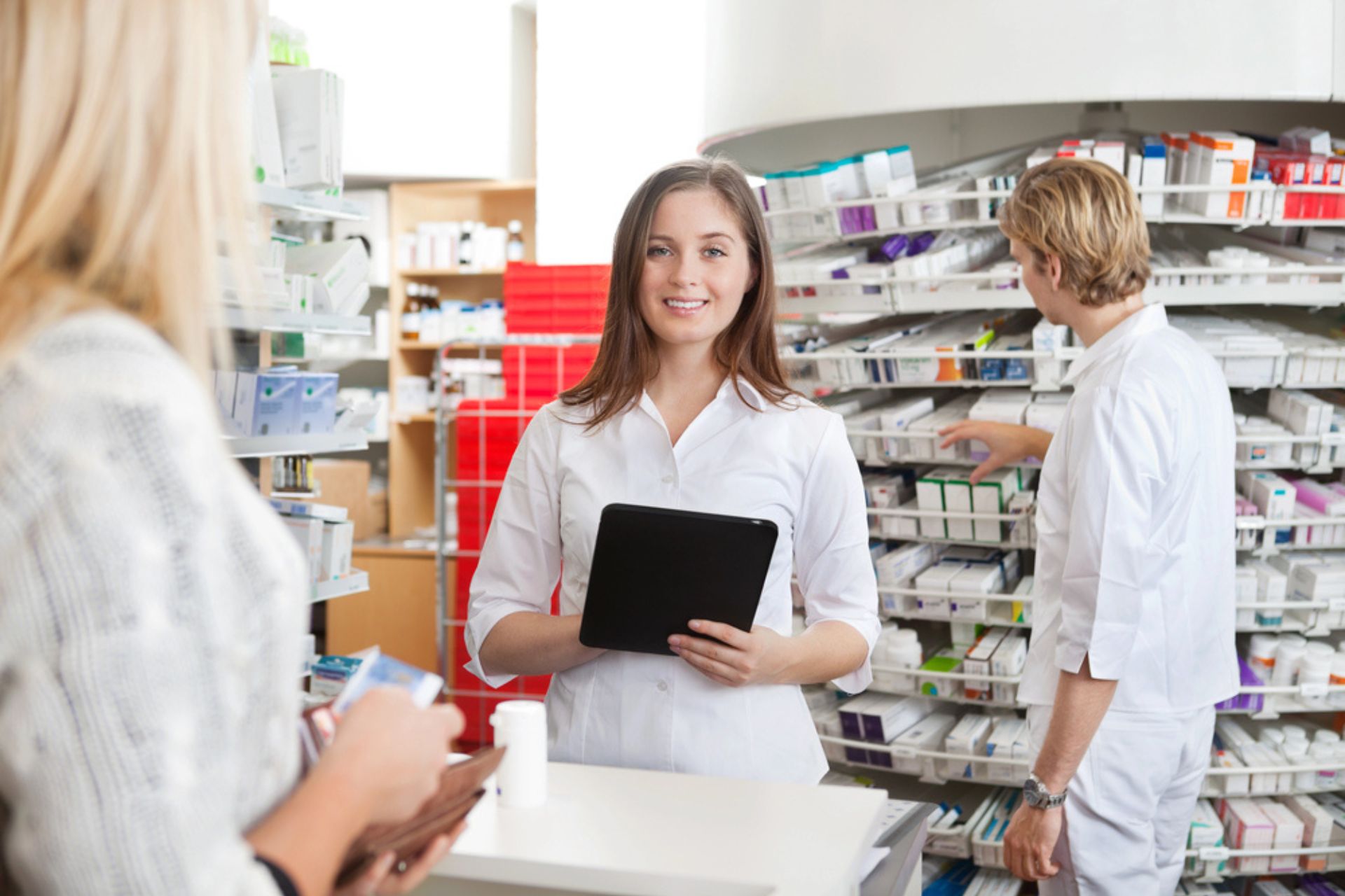 Pharmaciens travaillant dans une pharmacie, illustrant la gestion des dispositifs médicaux avec organisation et traçabilité pour garantir la conformité.