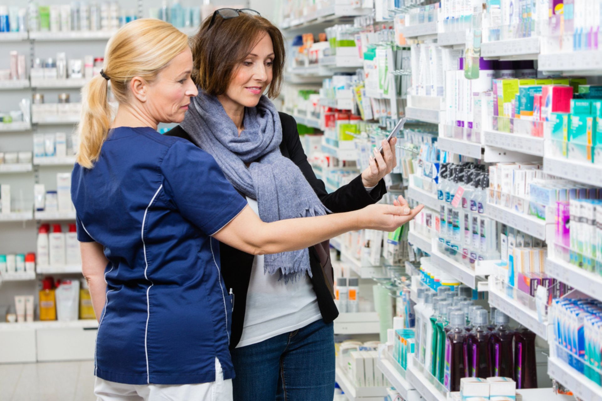 Pharmacienne conseillant une cliente dans une officine, illustrant l'importance de la conformité HAS et de la préparation aux inspections ARS.